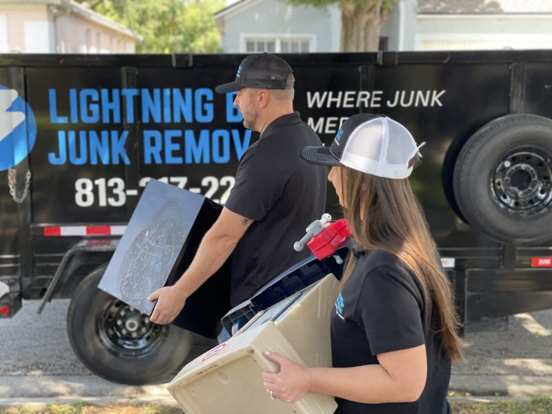 Junk removal professionals carrying household junk